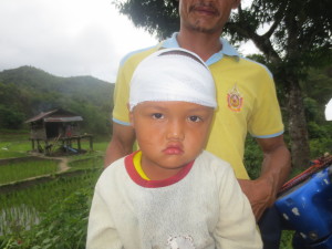 Finished! I only got one faint smile from this precious boy once the entire time! Next we did clinic in the house you can see in the background for 2 hours. This house is where the workers stay when they work in the rice field. It is quite a distance from their village, but they would run back and bring the sick people in to see us...